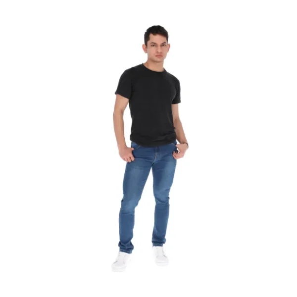 Modelo masculino con camiseta negra jeans azules calzado deportivo moderno